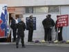 Police officers gather at the Penn Presbyterian Medical Center Emergency entrance in Philadelphia, Wednesday, Feb. 7, 2024, as they wait to hear on the health status of two officers who were injured earlier in the day at a home in East Lansdowne, Pa.