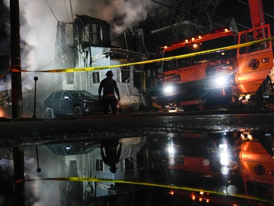 Firefighters work at the scene where two police officers were injured while responding to a reported standoff in East Lansdowne, Pa., on Wednesday, Feb. 7, 2024.
