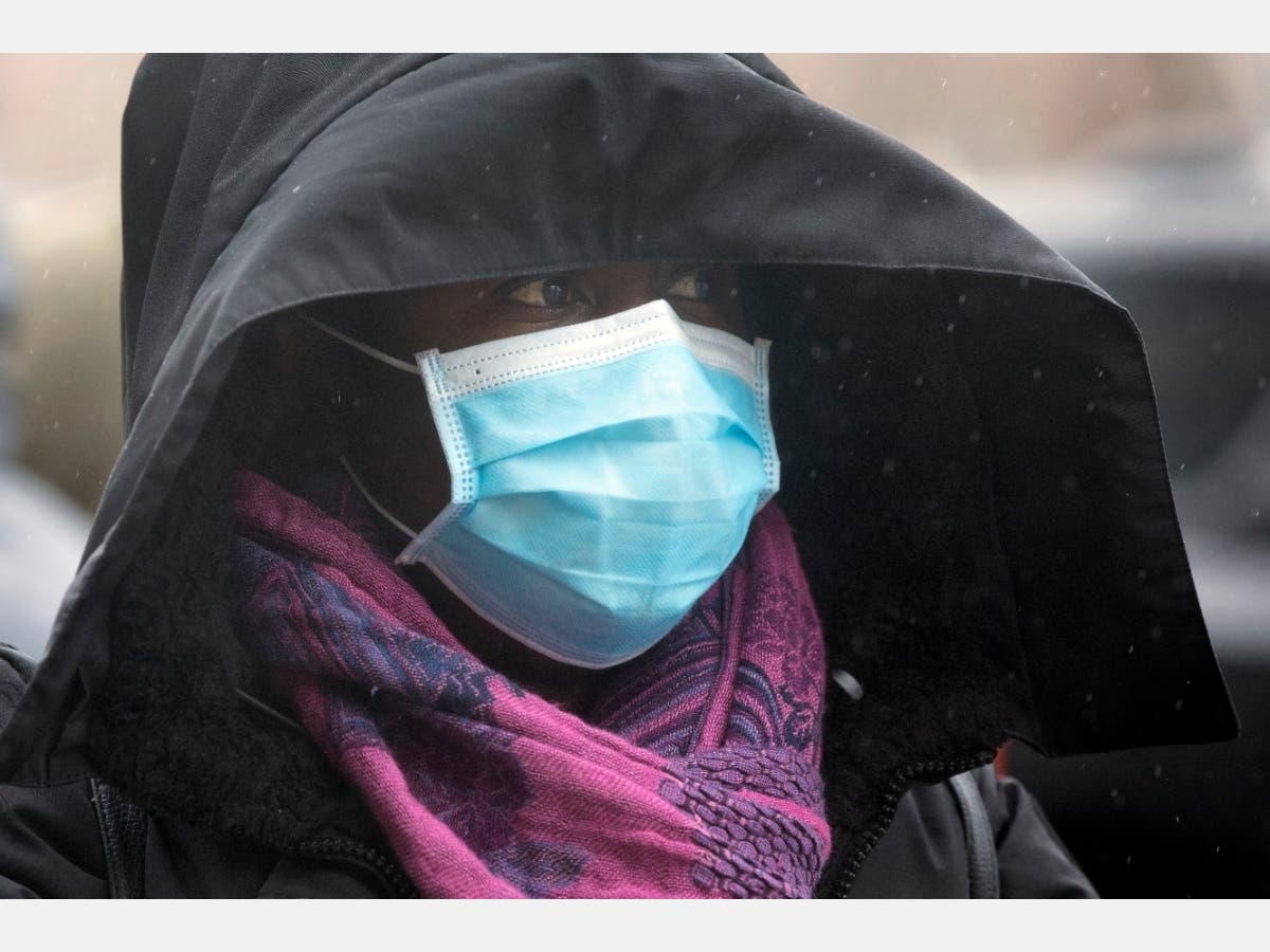 A woman wears a protective mask outside a supermarket in Chelsea on Friday. 