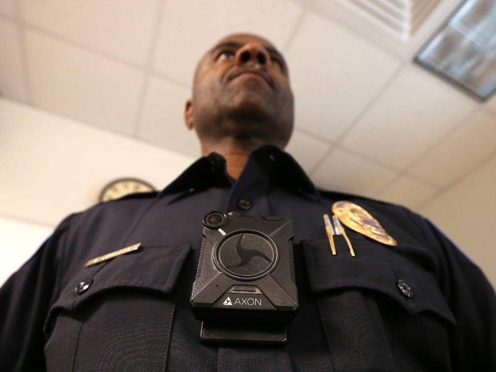 A Phoenix police officer demonstrates a body camera made by Axon, the same company that makes the Taser weapon.