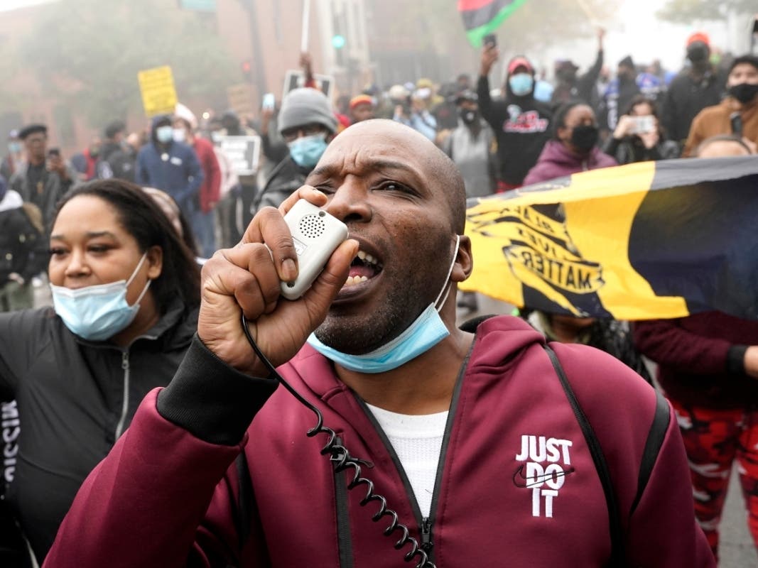 Rayon Edwards speaks on a megaphone as he marches with protesters during a protest rally for Marcellis Stinnette, who was killed by Waukegan police Tuesday.