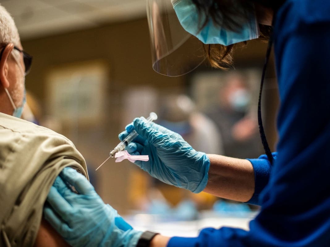 A Tyson Foods employee receives a COVID-19 vaccine at a North Carolina facility. Tyson, one of the world’s largest food companies, announced Tuesday that all of its approximately 120,000 U.S. employees must be vaccinated by Nov. 1.
