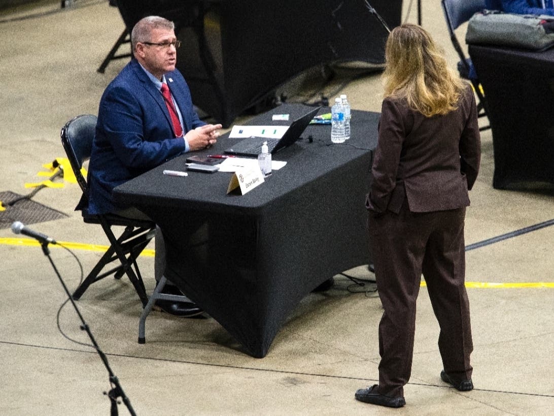 Then-State Rep. Darren Bailey (R-Louisville), left, speaks with a colleague before session begins at the Bank of Springfield Center, ahead of the Illinois House of Representatives' spring session in May 2020.