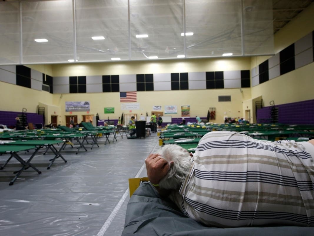 An evacuee lies on a cot at an evacuation shelter for people with special needs, in preparation for Hurricane Dorian, at Dr. David L. Anderson Middle School in Stuart, Fla., Sunday, Sept. 1, 2019. 