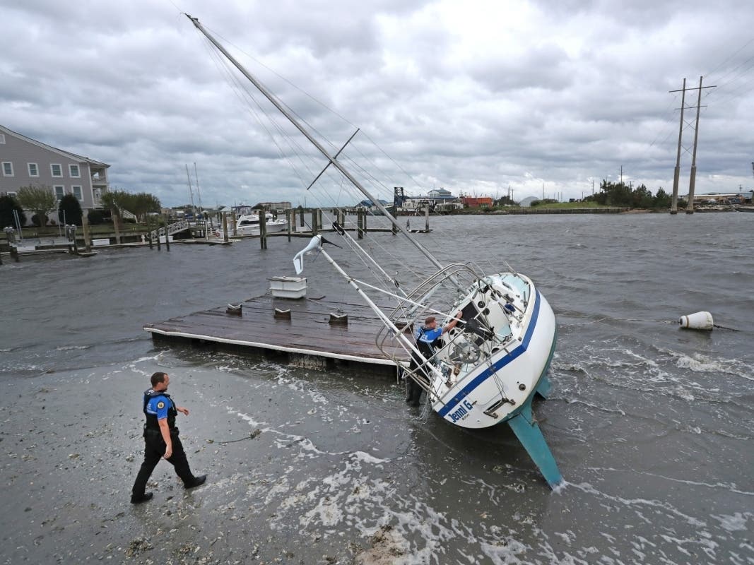 Beaufort Police Officer Curtis Resor, left, and Sgt. Micheal Stepehens check a sailboat for occupants in Beaufort, N.C. after Hurricane Dorian passed the North Carolina coast on Friday, Sept. 6, 2019. 
