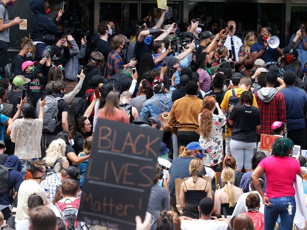 Protesters surround Richmond Mayor Levar Stoney, right holding megaphone, as he attempts to address a large crowd in front of City Hall, Tuesday June 2, 2020, in Richmond.
