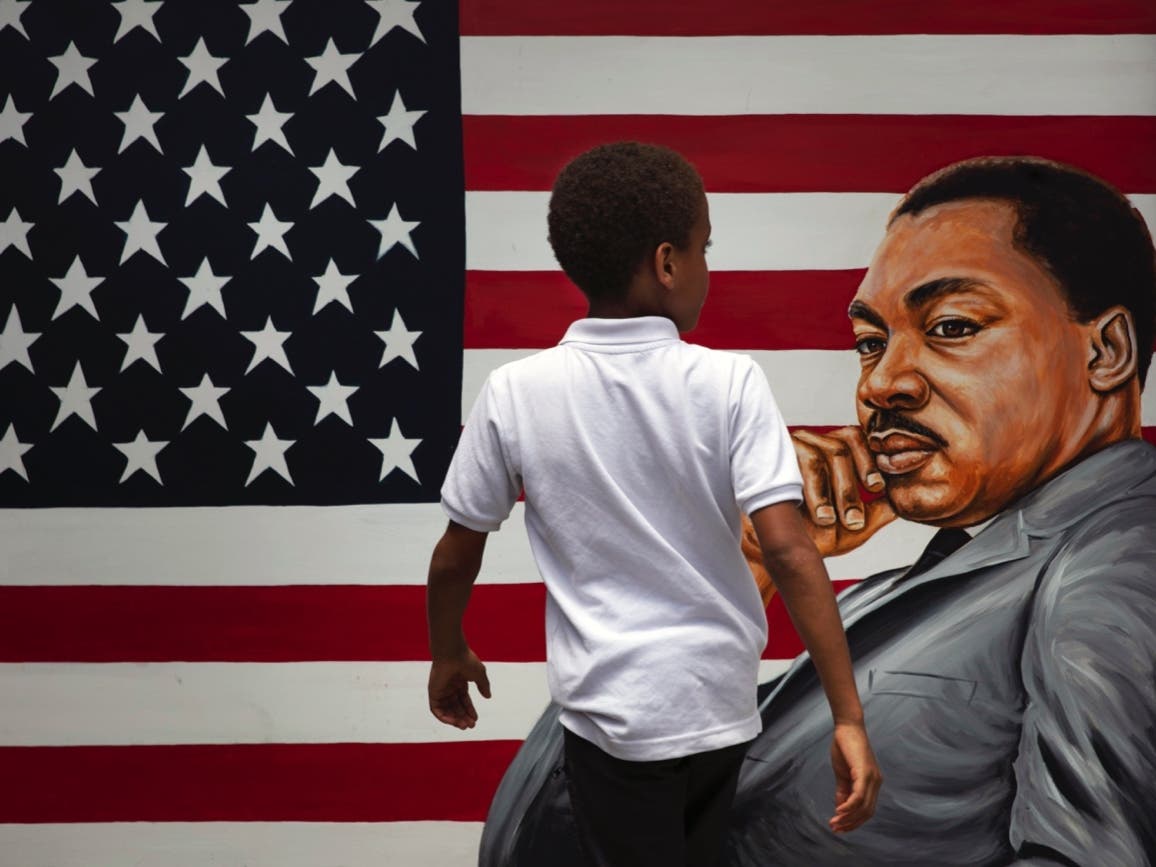 A young boy walks past a painting of Dr. Martin Luther King Jr. during a Juneteenth celebration in Los Angeles. 
