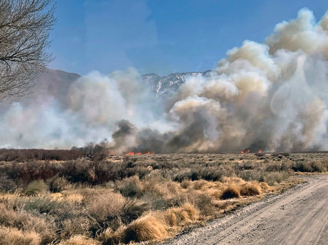 This photo provided by CAL FIRE San Bernardino Unit Public Information Office shows smoke and fire from a wildfire near in Owens Valley, Calif. on Thursday, Feb. 17, 2022. 