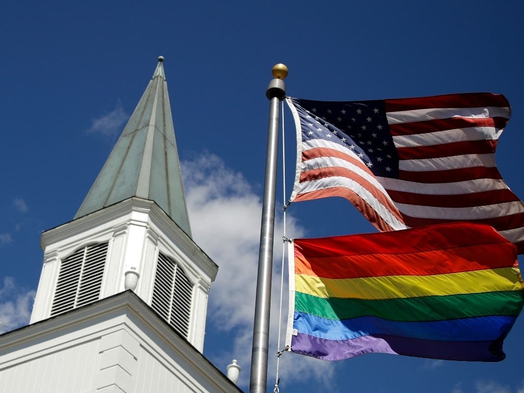 April 19, 2019 file photo, a gay pride rainbow flag flies along with the U.S. flag.