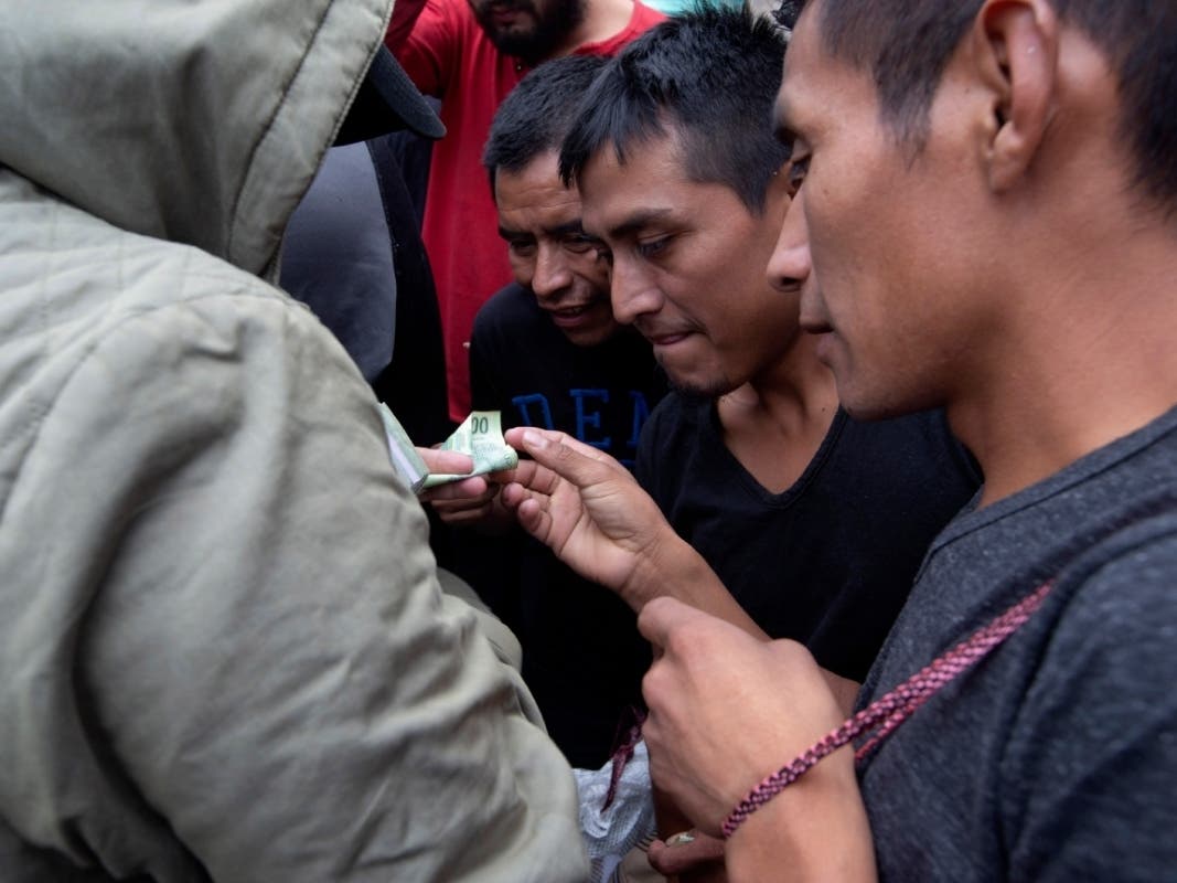 Guatemalan men who were deported from the United States, change money after arriving at an Air Force base in Guatemala. 