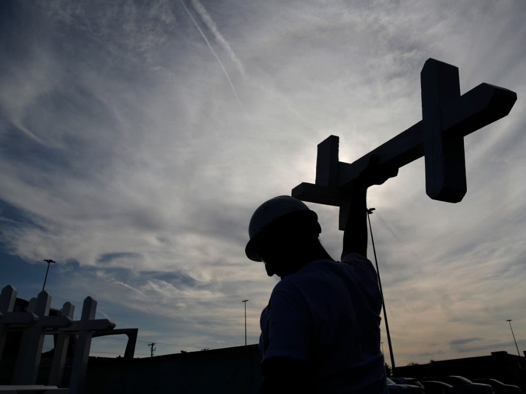 Greg Zanis prepares crosses to place at a makeshift memorial for victims of a mass shooting at a shopping complex on Saturday, Aug. 3, 2019. The death toll has risen to 22 and more than two dozen others were injured.
