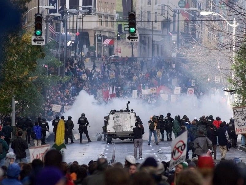 In this Nov. 30 1999, file photo, Seattle police use tear gas to push back World Trade Organization protesters in downtown Seattle.