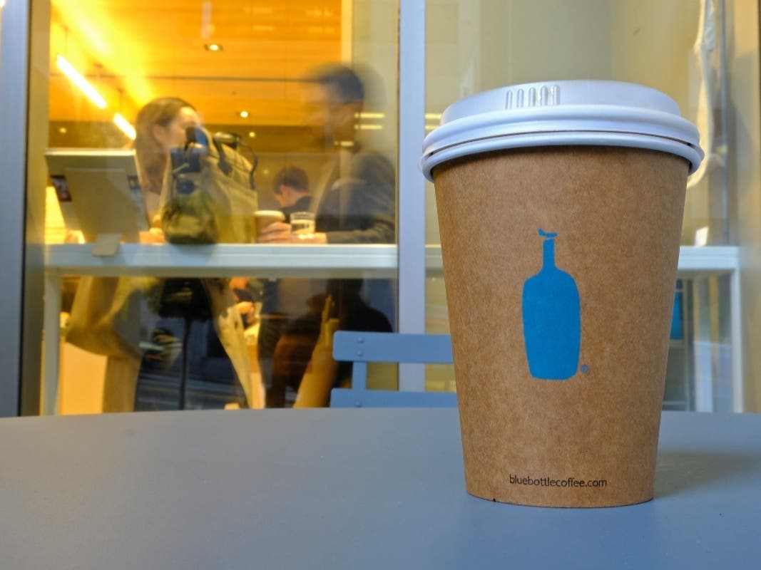 A Blue Bottle Coffee paper to-go cup sits on a table outside one of its cafes in San Francisco. The Oakland-based chain says it's getting rid of disposable cups at two locations next year. 