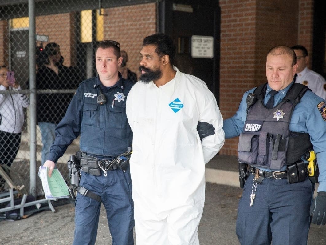 Ramapo police officers escort Grafton Thomas from Ramapo Town Hall to a police vehicle, Sunday, Dec. 29, 2019.