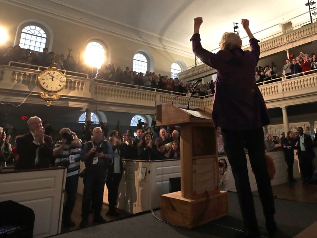 Elizabeth Warren estures to the crowd during a campaign event at the Old South Meeting House.