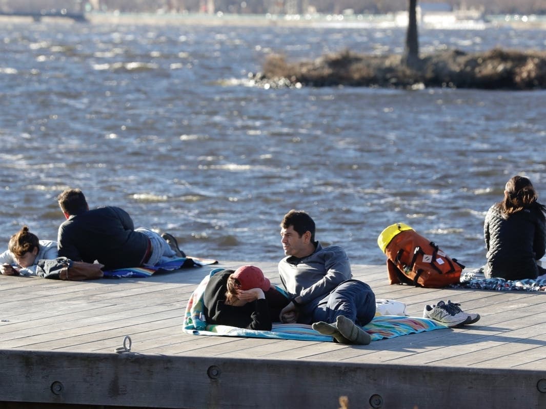 Phil Taneyhill (center right) and his wife Elisa (center left) sit on a dock in the Charles River Esplanade park, in Boston Sunday.