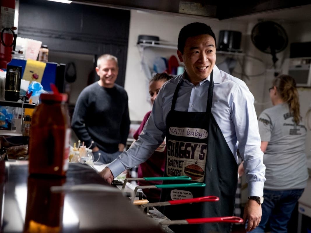 Democratic presidential candidate Andrew Yang smiles as he flips hamburgers at a campaign stop at Shaggy's Gourmet Burgers, at a recent campaign stop in Wapello, Iowa. 
