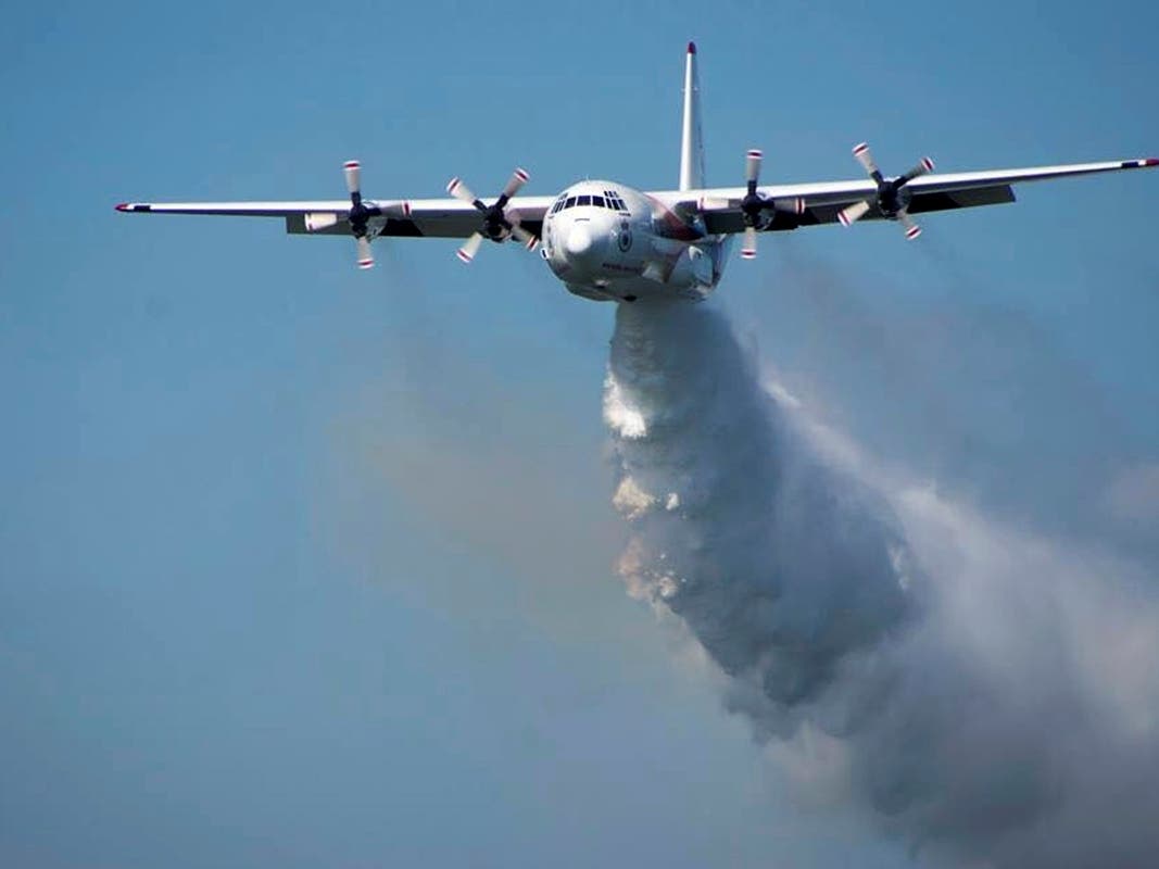 In this undated photo released from the Rural Fire Service, a C-130 Hercules plane called "Thor" drops water during a flight in Australia.