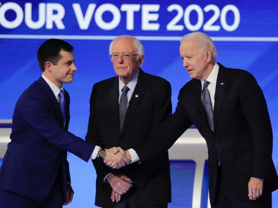 From left, Democratic presidential candidates former South Bend Mayor Pete Buttigieg, shakes hands with former Vice President Joe Biden as Sen. Bernie Sanders, I-Vt., watches Friday.