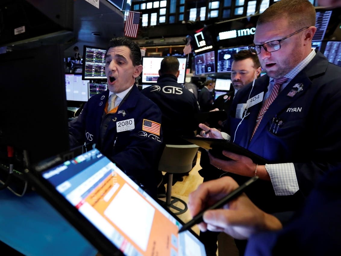 Specialist Peter Mazza (left) works with traders Monday at his post on the floor of the New York Stock Exchange. Stocks fell sharply Monday amid fresh concerns about the global spread of the new coronavirus.