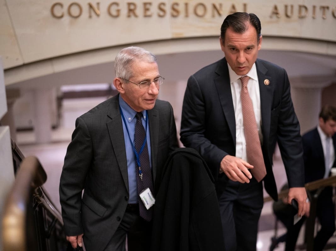 Dr. Anthony Fauci, left, director of the National Institute of Allergy and Infectious Diseases, speaks with Rep. Tom Suozzi, D-N.Y., right, after updating members of Congress on the coronavirus outbreak.