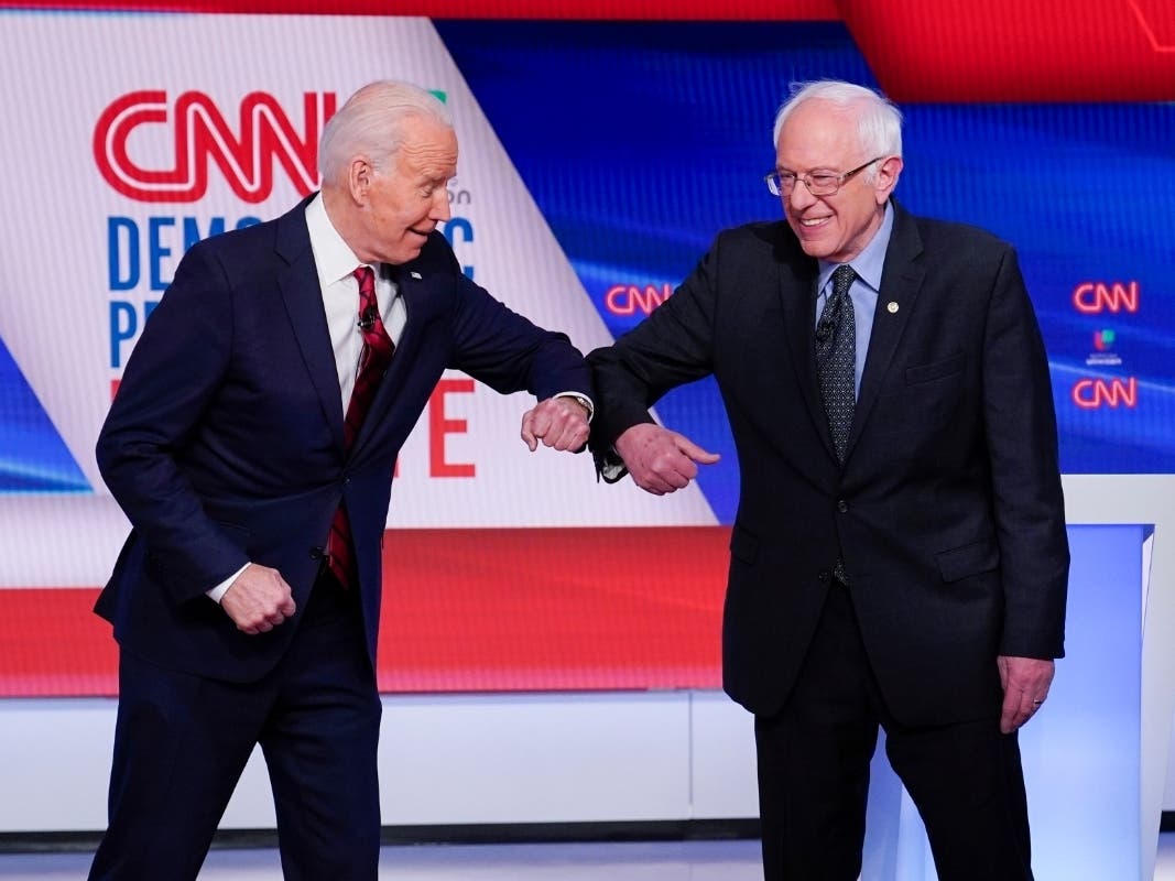 Former Vice President Joe Biden, left, and Sen. Bernie Sanders, I-Vt., right, greet one another before they participate in a March 15 Democratic presidential primary debate.
