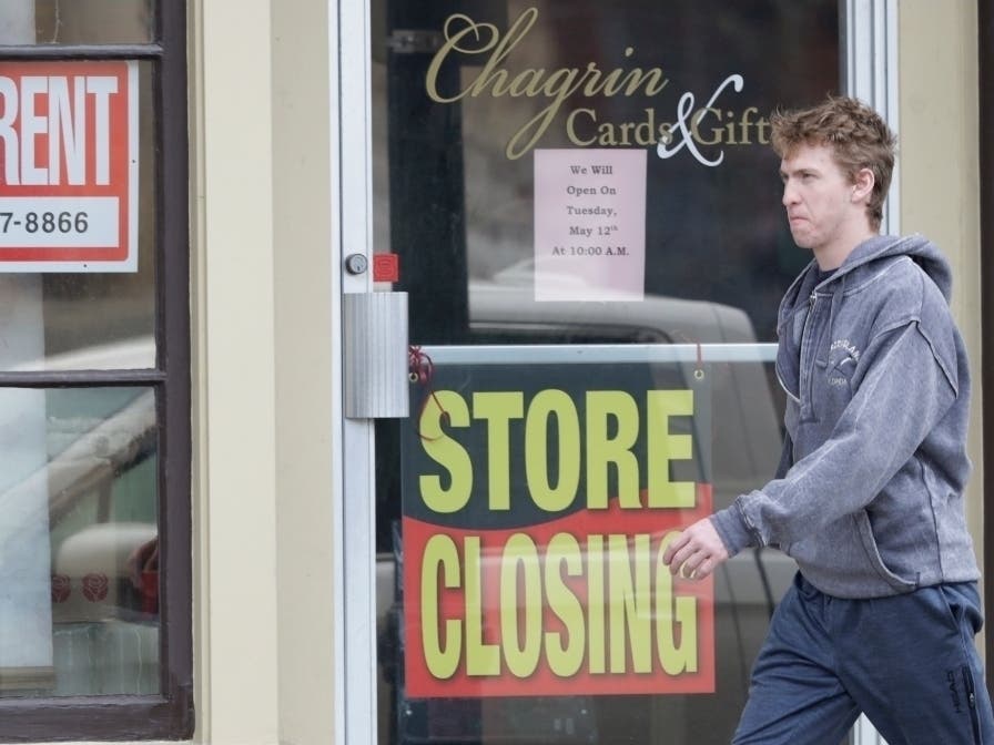 A man walks past a closed business in Chagrin Falls, Ohio. The U.S. economy shrank at a 4.8 percent annual rate last quarter as the coronavirus pandemic shut down much of the country.