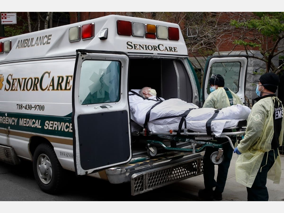 A patient is loaded into an ambulance by emergency medical workers outside Cobble Hill Health Center.