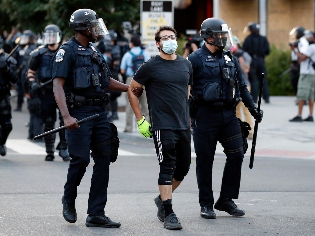 A demonstrator is detained by police during a protest in Washington D.C. on Monday.