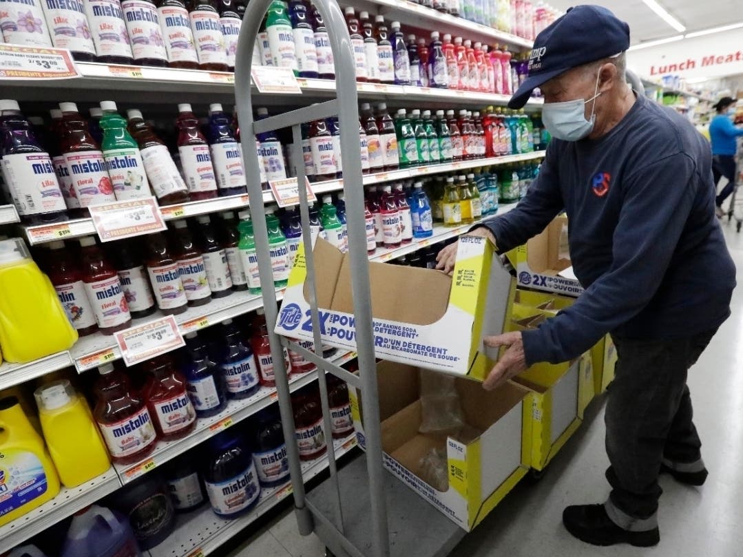 Juan Santos, shown here stocking shelves at the Presidente Supermarket in the Little Havana neighborhood of Miami, is among Americans still working after the coronavirus caused millions of layoffs. They have begun to slow as more workers are called back.