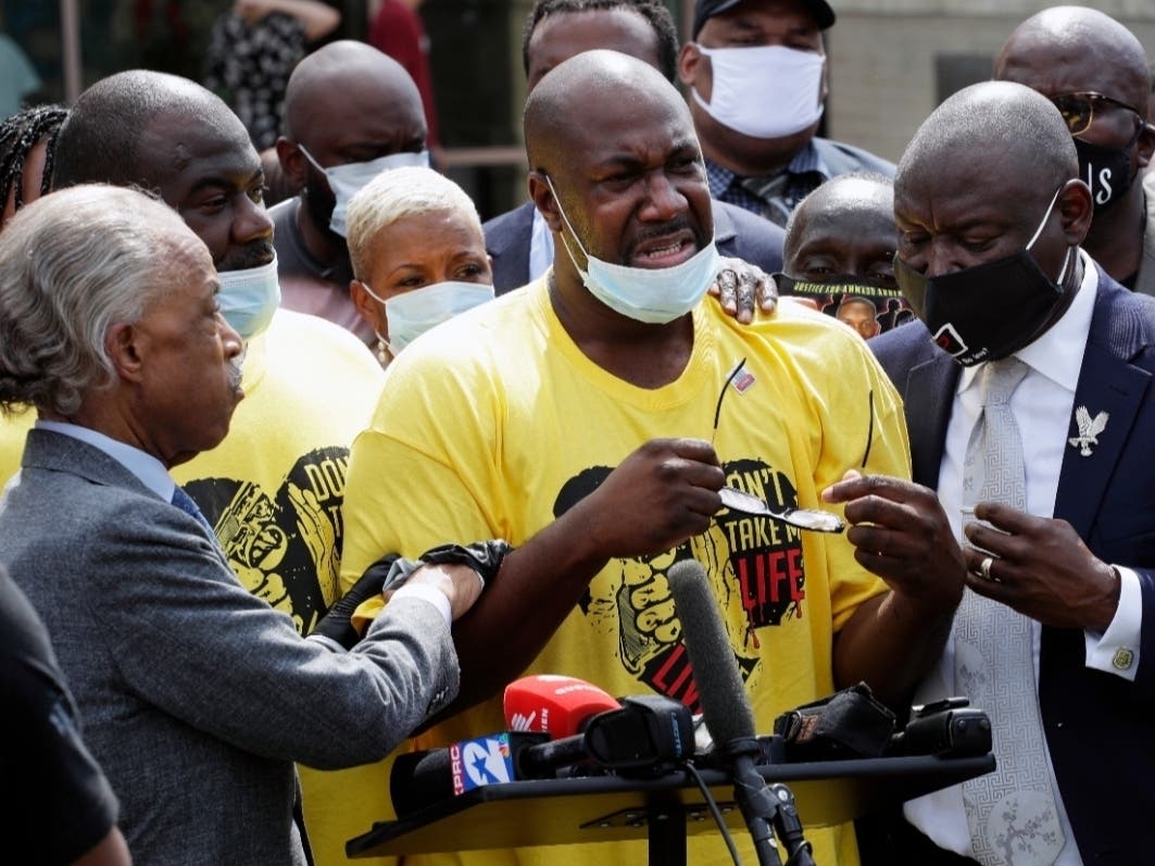 Philonise Floyd, center is comforted by the Rev. Al Sharpton, left, and attorney Benjamin Crump, right at a news conference during a public visitation for his brother George Floyd at The Fountain of Praise church in Houston, Monday, June 8, 2020.