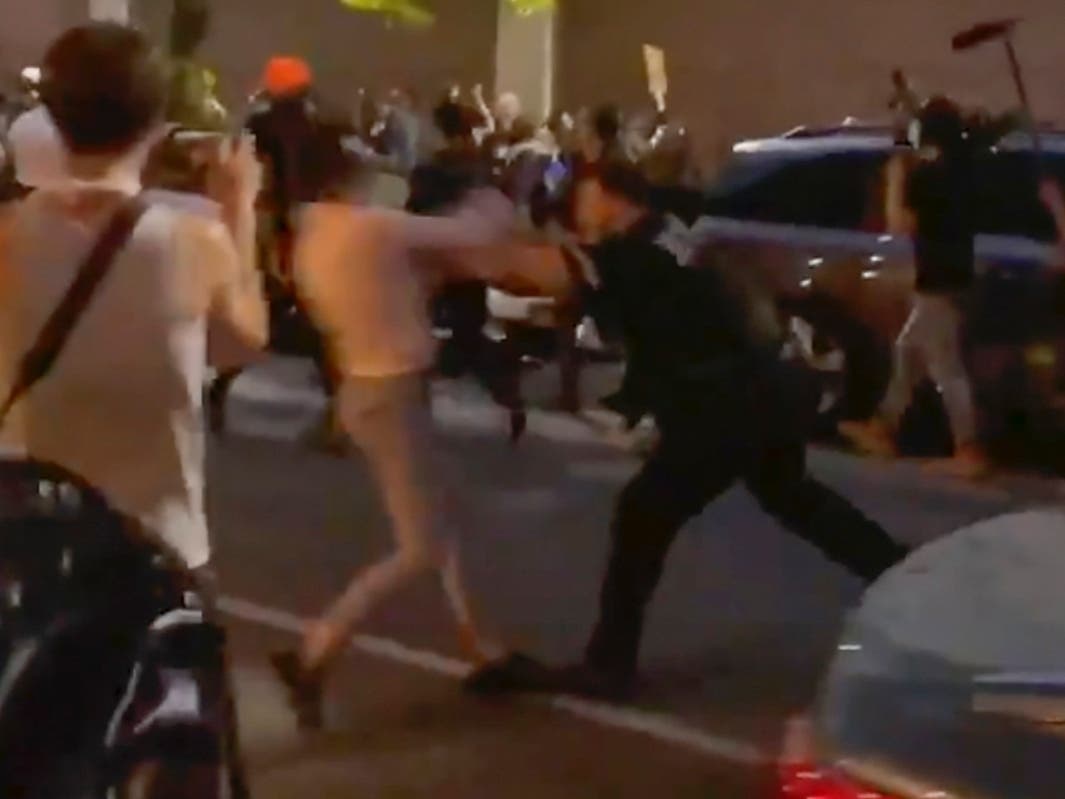 New York police officer Vincent D'Andraia, right, pushes protester Dounya Zayer during a protest in Brooklyn. D'Andraia is facing criminal charges.