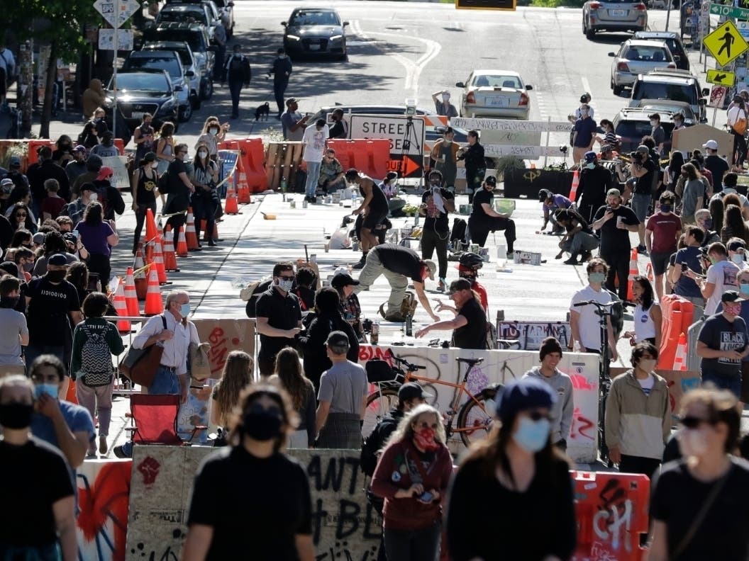 Artists paint large letters that read "Black Lives Matter" painted on a street near Cal Anderson Park inside what is being called the "Capitol Hill Autonomous Zone" in Seattle.