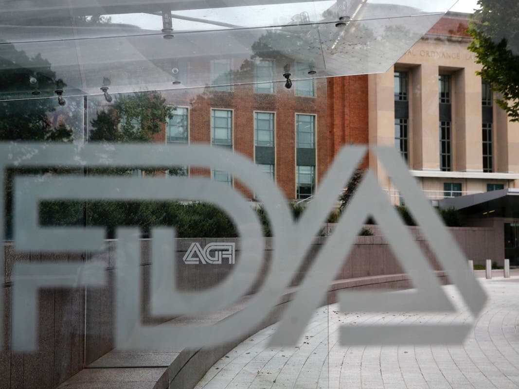 In this Aug. 2, 2018, file photo, the U.S. Food and Drug Administration (FDA) building is visible behind FDA logos at a bus stop on the agency's campus in Silver Spring, Md.