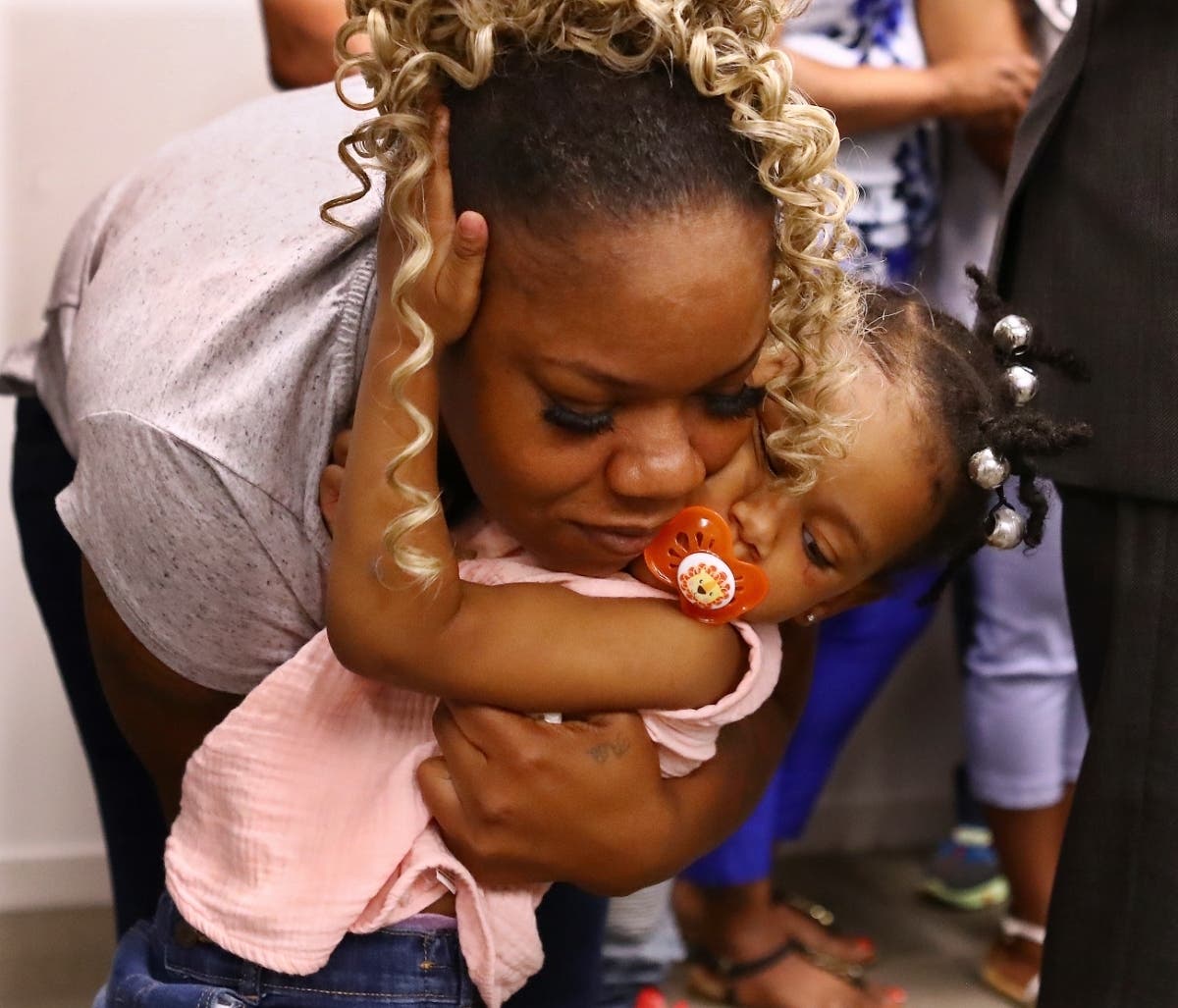 Tomika Miller, the wife of Rayshard Brooks, hugs their daughter Memory, 2, during the family press conference on June 15 in Atlanta. Brooks was killed by an APD officer Friday and the family was determined that his death spark positive change.