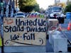 A sign on a barricade reads "United we stand divided we fall," as a truck and other heavy equipment from the Seattle Department of Transportation is staged at the the CHOP (Capitol Hill Occupied Protest) zone in Seattle, Friday, June 26, 2020.