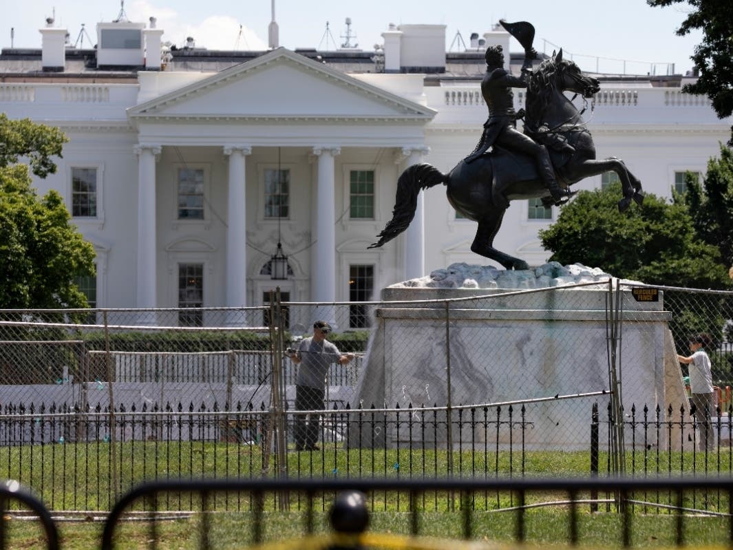 The base of the statue of former president Andrew Jackson is power washed inside a newly closed Lafayette Park.