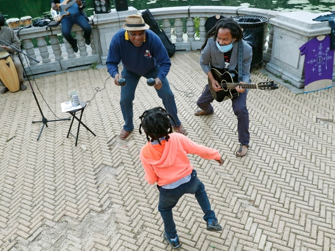 Alix Julien, above, center, encourages 6-year-old Nova Sankara to dance as Alegba Jahyile, right, leads the band Alegba and Friends in a nightly concert at Brooklyn's Prospect Park.