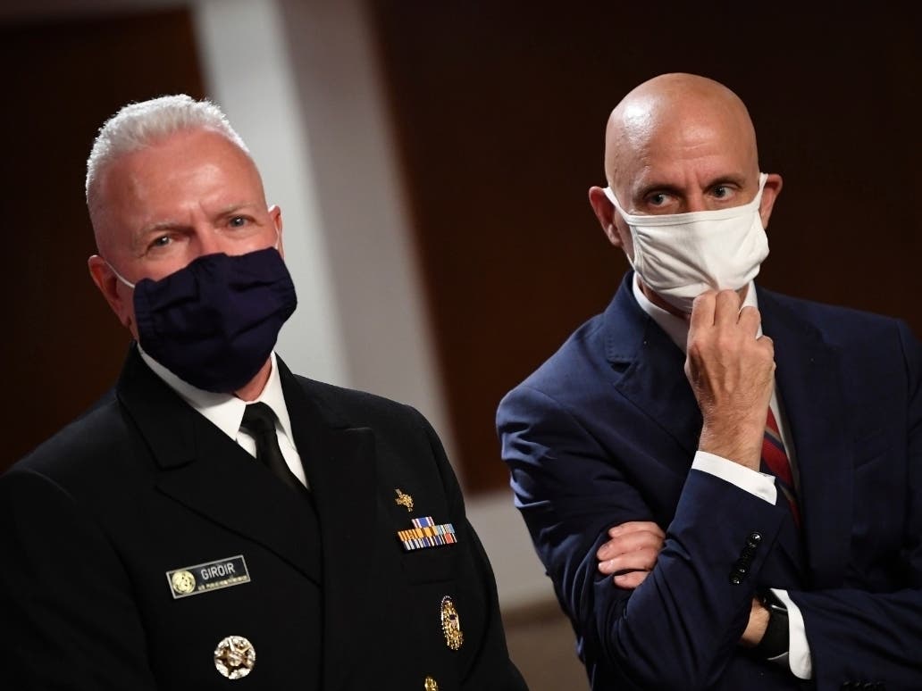 Adm. Brett Giroir, left, director of the U.S. coronavirus diagnostic testing, and Food and Drug Administration Commissioner Stephen Hahn, prepare to testify before a Senate hearing Tuesday.