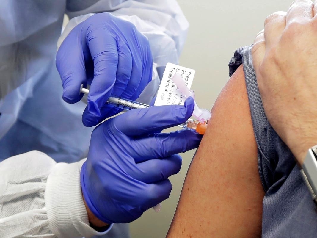 In this March 16, 2020, file photo, a subject receives a shot in the first-stage safety study clinical trial of a potential vaccine by Moderna for COVID-19, the disease caused by the new coronavirus.