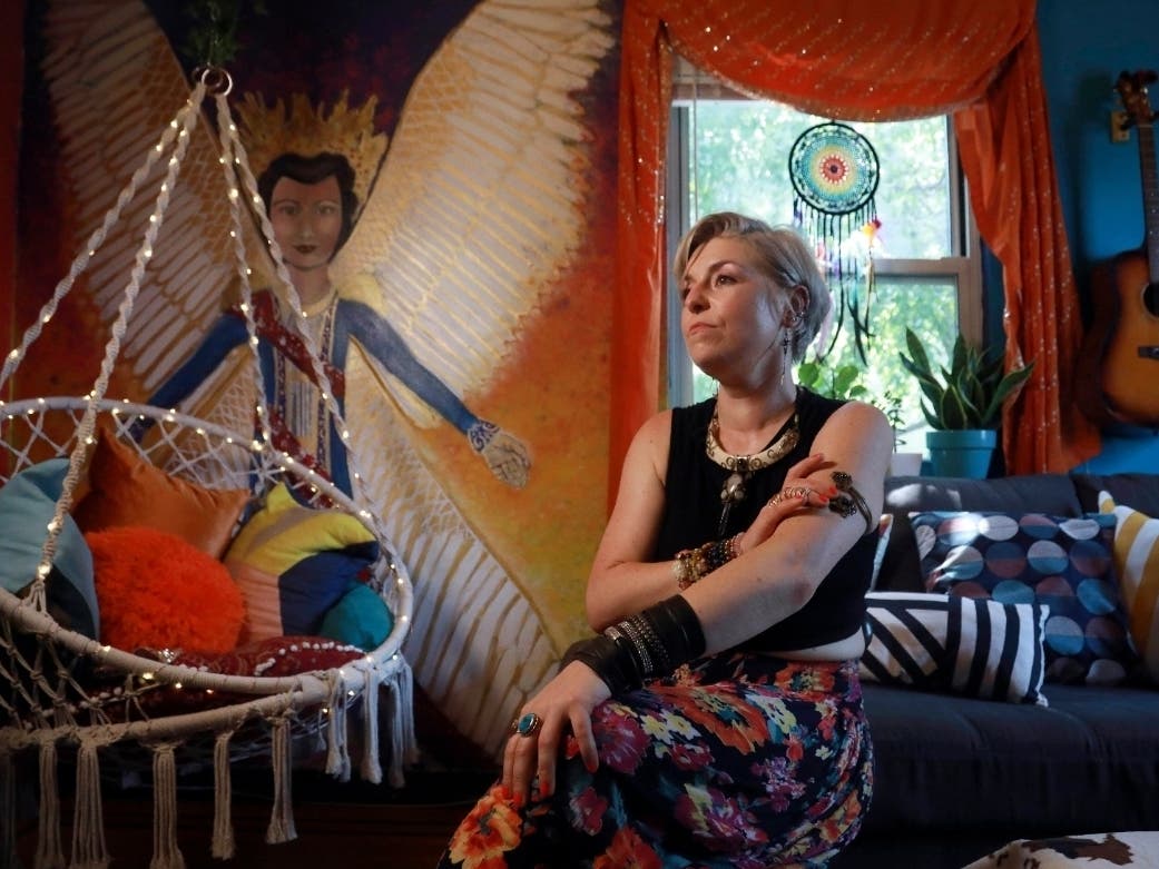 Rachel Berry, in New York City since 2004, from Laurel, Maryland, sits in her living room decorated with her art, 