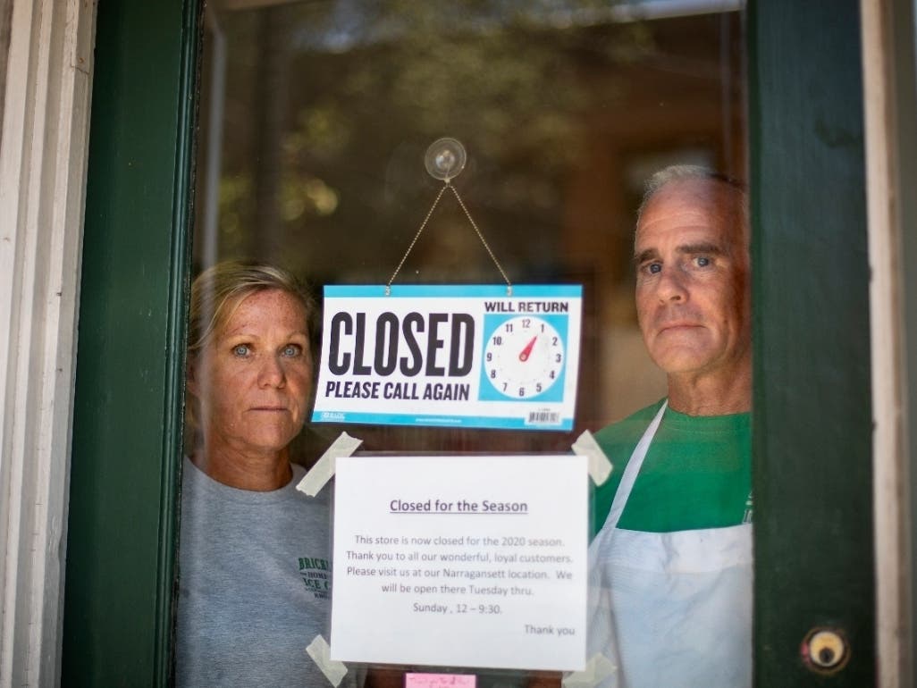 Steve, right, and Chris Brophy, husband and wife owners of Brickley's Ice Cream, look out from the store they closed after teenage workers were harassed by customers who refused to wear a mask or socially distance, in Wakefield, Rhode Island, Wednesday.