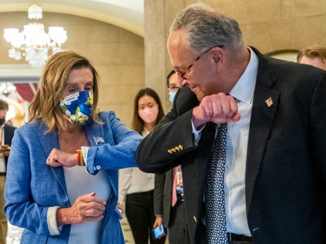 House Speaker Nancy Pelosi of Calif., gives Senate Minority Leader Chuck Schumer of N.Y., an elbow bump as Schumer leaves following a meeting at the Capitol with White House chief of staff Mark Meadows and Treasury Secretary Steven Mnuchin.