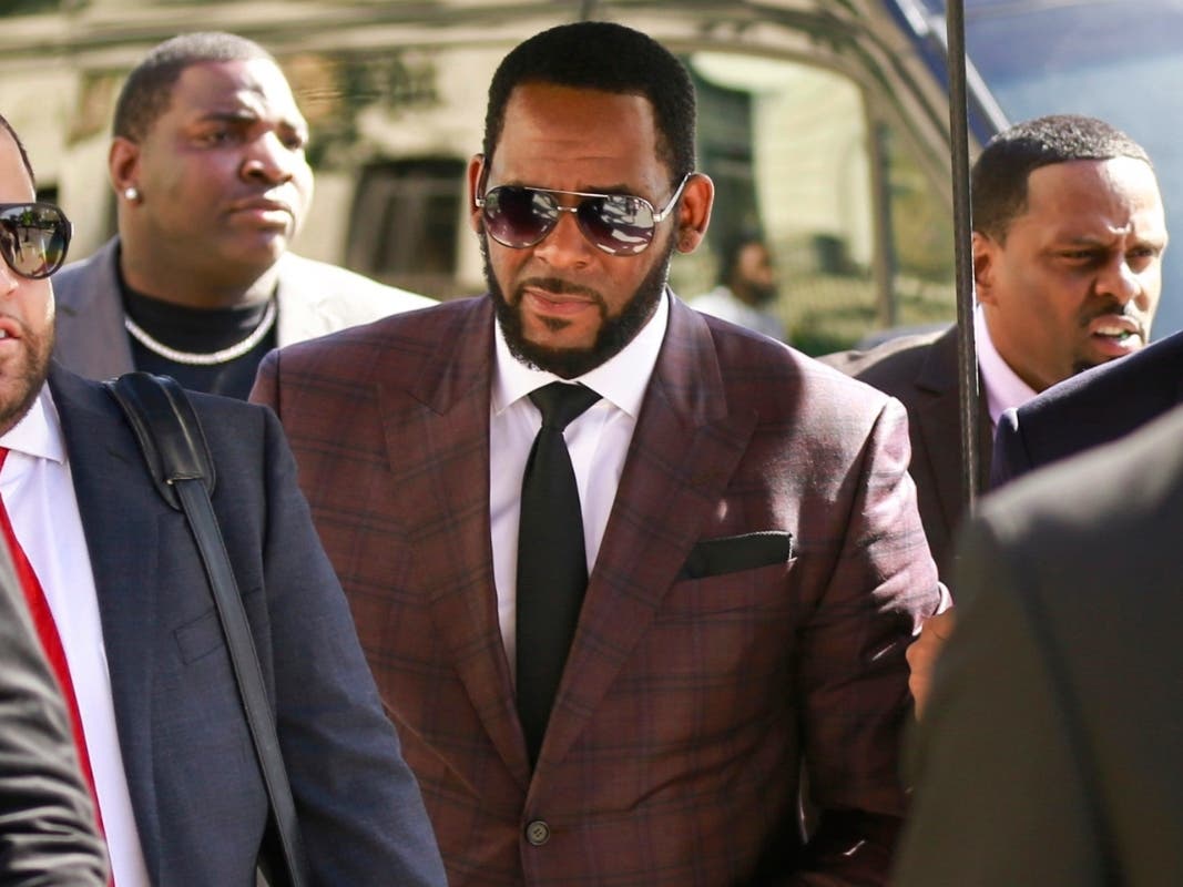 R&B singer R. Kelly, center, arrives for an arraignment on sex-related felonies in Chicago.