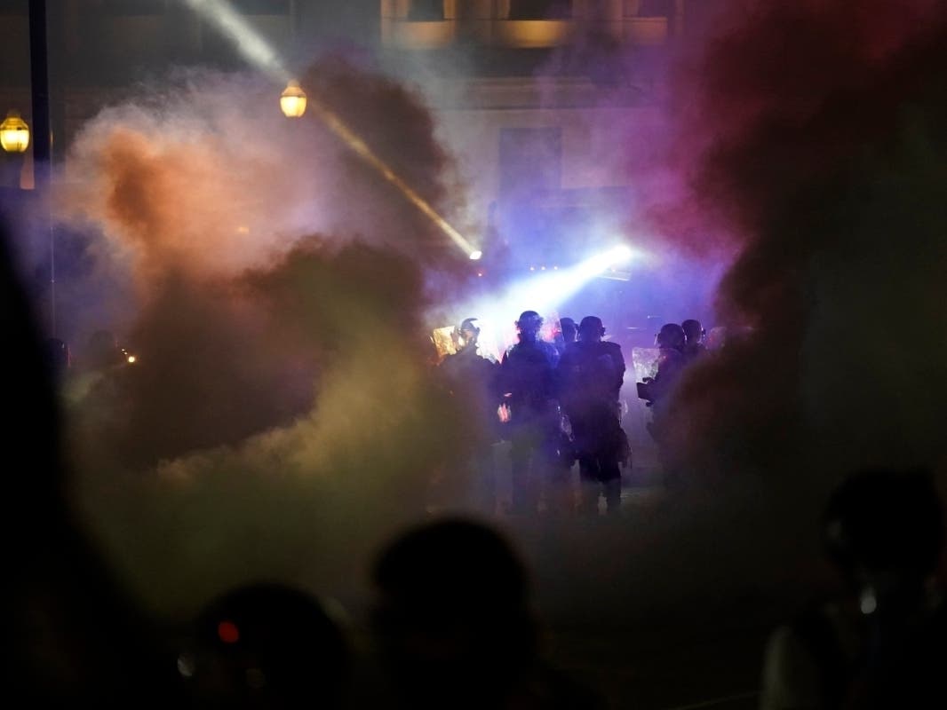 Police in riot gear clear the area in front of Kenosha County Courthouse during clashes with protesters late Tuesday, Aug. 25, 2020, in Kenosha, Wis.