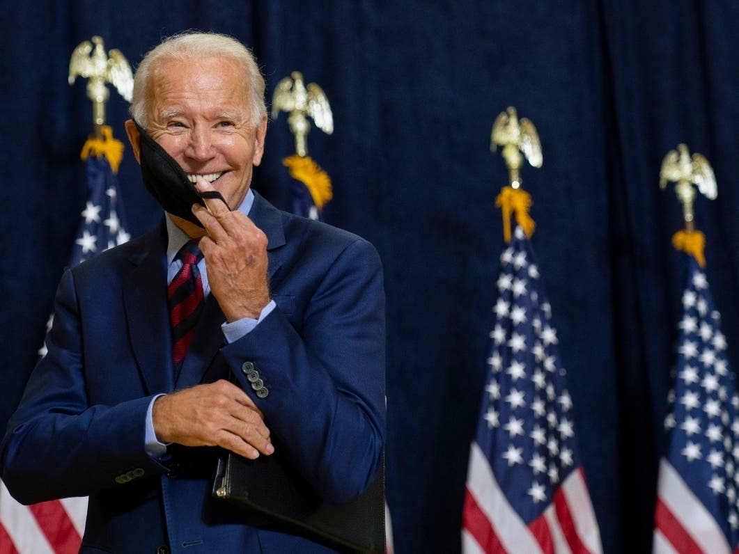Democratic presidential candidate former Vice President Joe Biden puts on his face mask after speaking to media in Wilmington, Delaware, Friday. He said he will undergo regular coronavirus testing through the rest of the campaign.