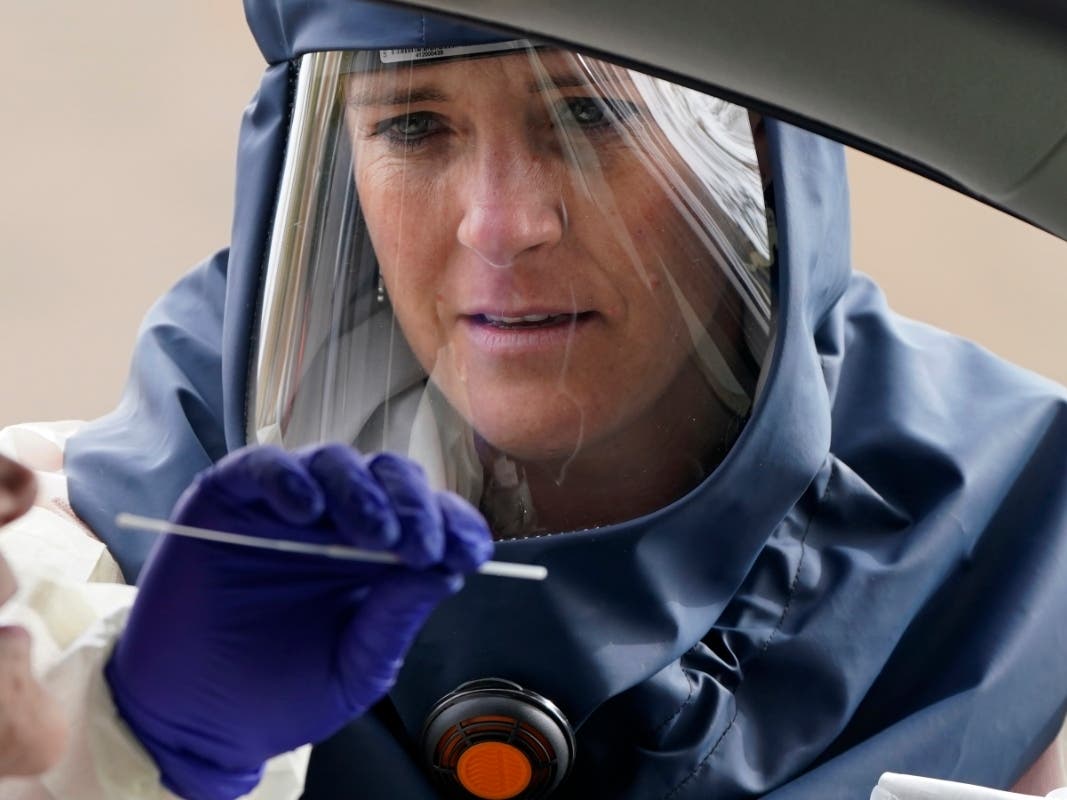 Salt Lake County Health Department public health nurse Lee Cherie Booth performs a coronavirus test outside the Salt Lake County Health Department in Salt Lake City.