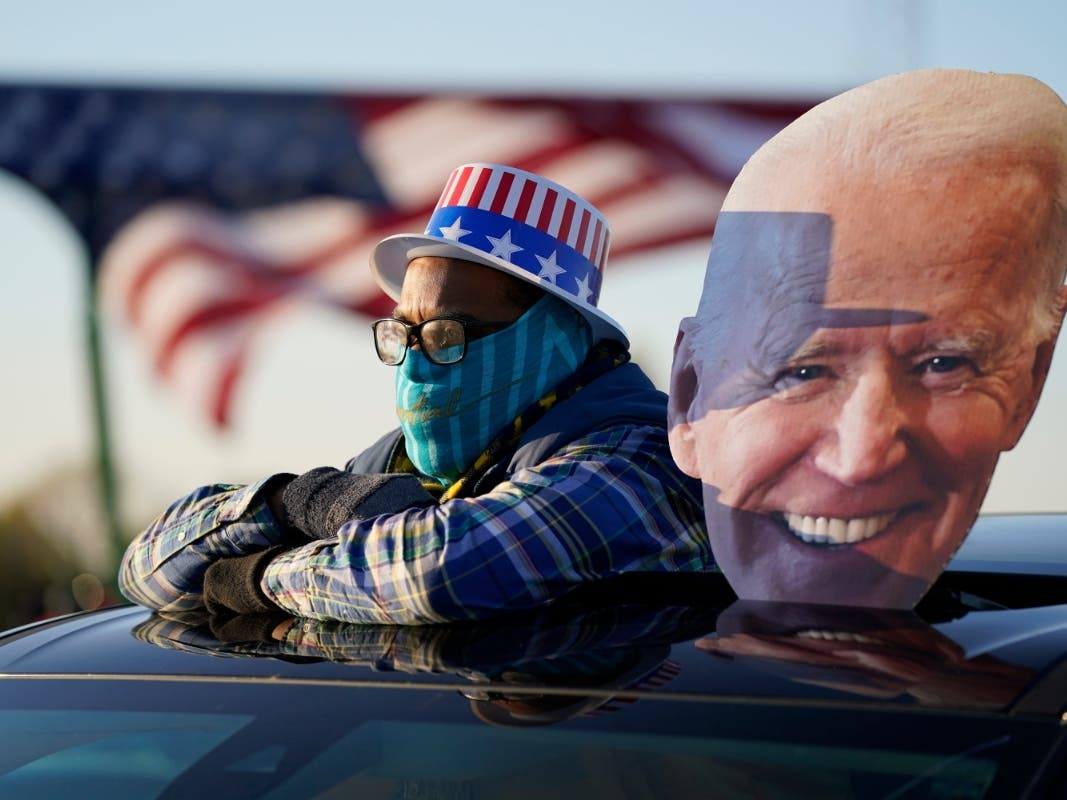 A supporter watches as Democratic presidential candidate former Vice President Joe Biden and former President Barack Obama speak at a rally at Belle Isle Casino in Detroit.