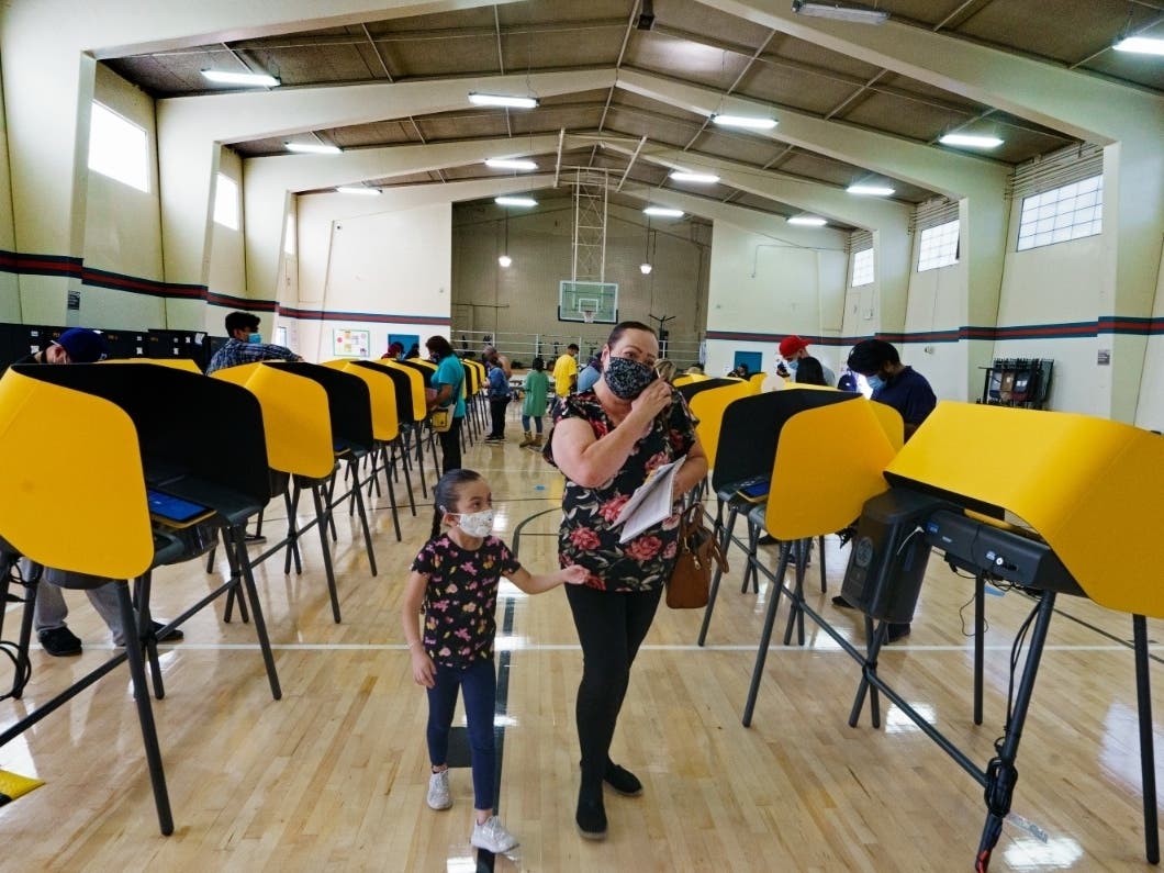 East Los Angeles voter Laura Cortez, 54, with her granddaughter Daniela 6, walk after casting her ballot in-person on Election Day inside the Ruben F. Salazar Park recreation center, an official vote center in East Los Angeles.