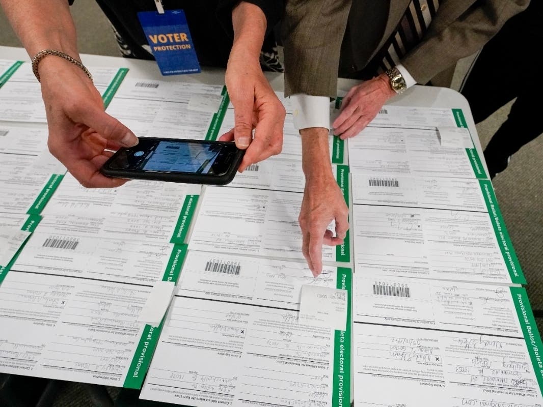 A canvas observer photographs Lehigh County provisional ballots as vote counting in the general election continues on Friday in Allentown, Pa. 